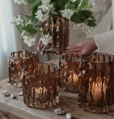 Bild av kastanjebruna glaslyktor med blommor på rustikt trä