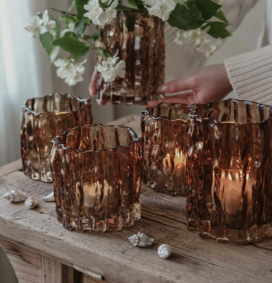 Bild: Glaslyktor och blommor i varm, naturnära inredning