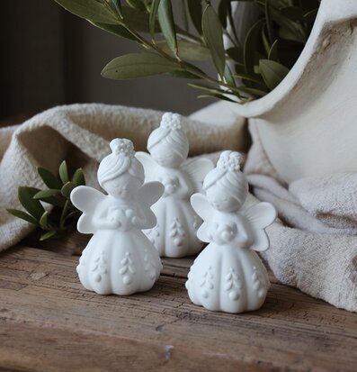 Bild med vita änglar i keramik på rustikt trä med olivkvistar