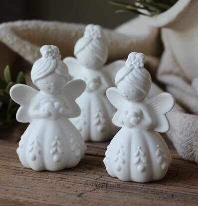 Bild på tre vita keramikänglar med hjärta och blommor