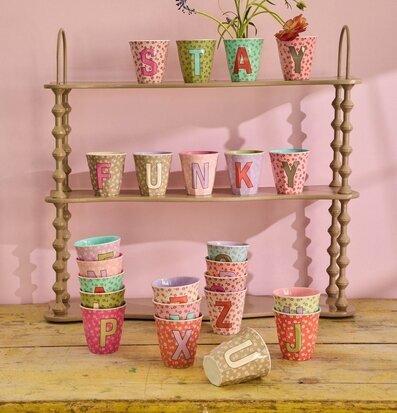 Bild på färgstarka melaminmuggar med bokstäver och blommor