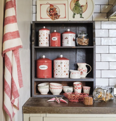 Bild på julig kökshörna med burkar, brickor och säsongsdetaljer