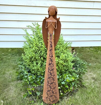 Bild på rostig metallängel som trädgårdsdekoration ute