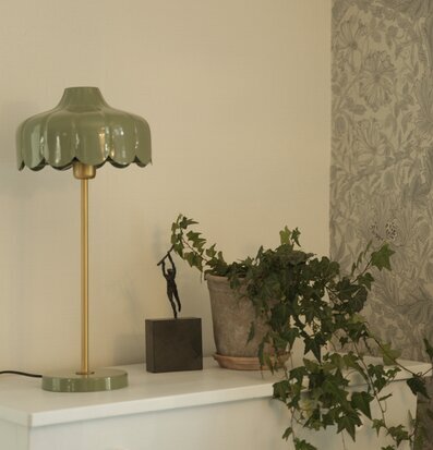Bild av harmoniskt vardagsrum med bordslampa och murgröna