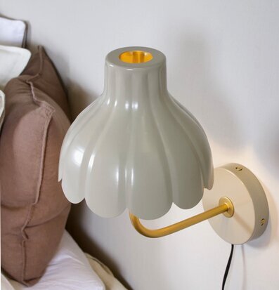 Bild på elegant vägglampa i beige och guld i harmoniskt sovrum