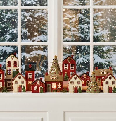 Bild av julig fönsterbänk med ljuslyktor, snö och vinterlandskap