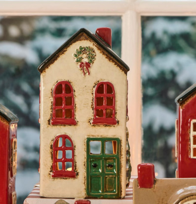 Bild av keramikljuslyktor med julkrans i vinterfönster