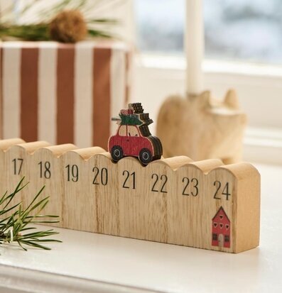 Bild av träjulkalender med bil och paket – julstämning hemma