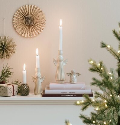 Bild av juldekorerad spiselkrans med änglar, böcker och gran