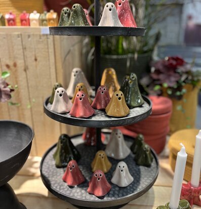 Bild av färgstarka dekorationsfigurer på våningsfat i butik