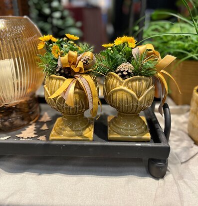 Bild: Gul pokalkruka med säsongsplantering och naturdetaljer