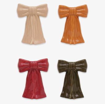 Bild på fyra glaserade rosetter i olika färger och former