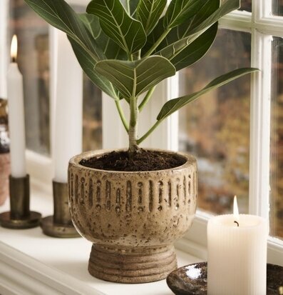 Bild av rustik blomkruka och tända ljus på fönsterbänk