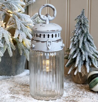 Bild av antikvit lanterna med vinterdekoration och konstsnö