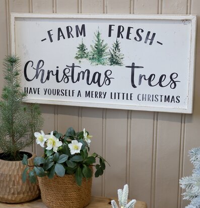 Bild av julig träskylt och växter i harmonisk vintermiljö