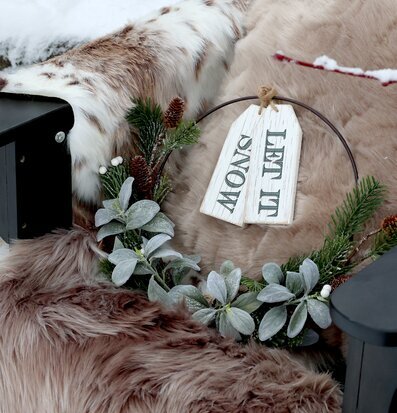 Bild av vintrig uteplats med filt, krans och snödetaljer