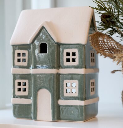 Bild av dekorativ ljuslykta som litet hus med vinterkänsla