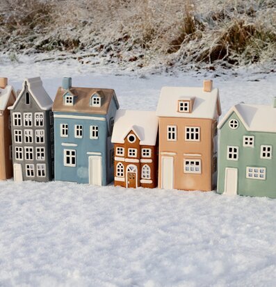 Bild av dekorativa vinterhus i snö – stämningsfull juldekor