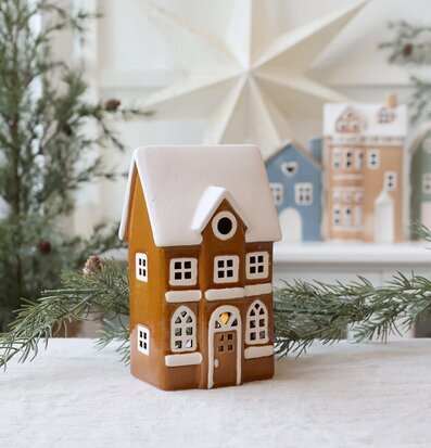 Bild på dekorativ ljuslykta i form av hus med vinterkänsla