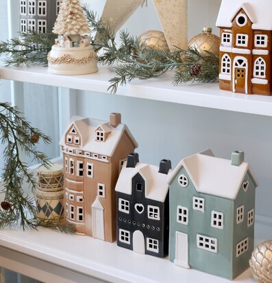 Bild på vinterinspirerad hylla med huslyktor och juldekorationer