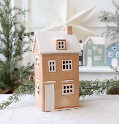 Bild av detaljrik ljuslykta hus i puderbeige med vit dekor