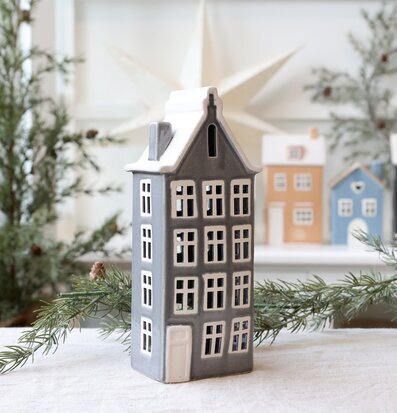 Bild av dekorativ ljuslykta som hus i vinterinspirerad miljö