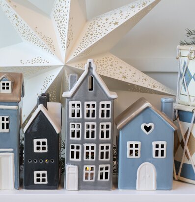 Bild med keramikhus, julstjärna och dekorativa trummor