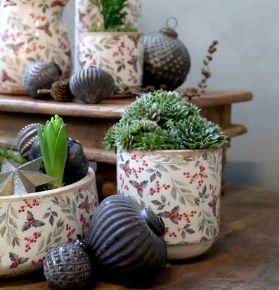 Bild med planteringskrukor och säsongsdekor i naturnära toner