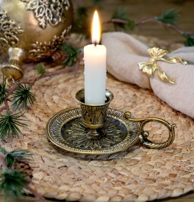 Bild på antik mässingsljusstake i rustik och ombonad dukning