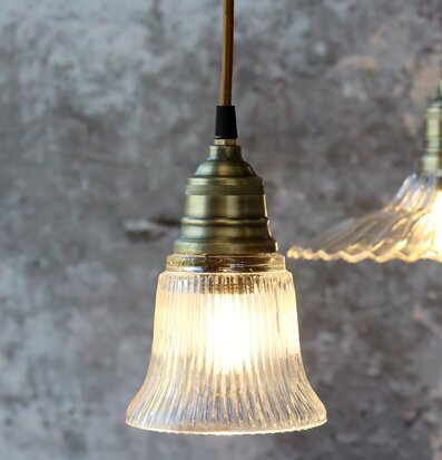 Bild på taklampa i mässing och räfflat glas med rustik bakgrund