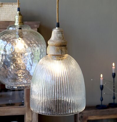 Bild på taklampor i glas och trä med stämningsfull belysning