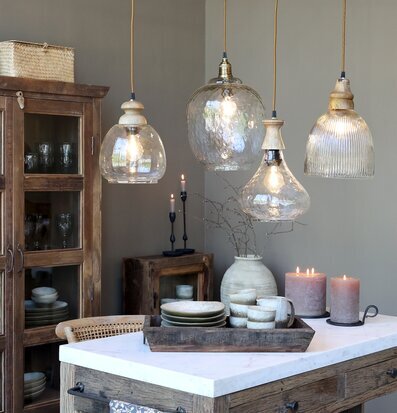 Bild på stilrent kök med taklampor i glas och naturmaterial