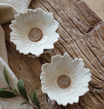 Bild av blomformade skålar i rustik miljö med naturdetaljer