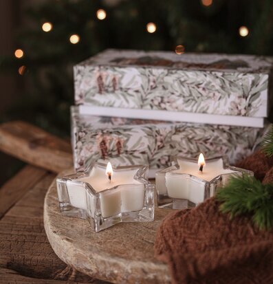 Bild av vintrig dukning med doftljus, träfat och julstämning