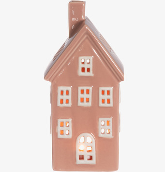 Bild av rosa keramiskt hus som ljuslykta med varm belysning