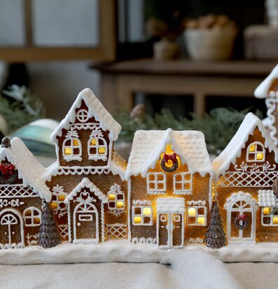 Bild av juldekoration med pepparkakshus och grankvist