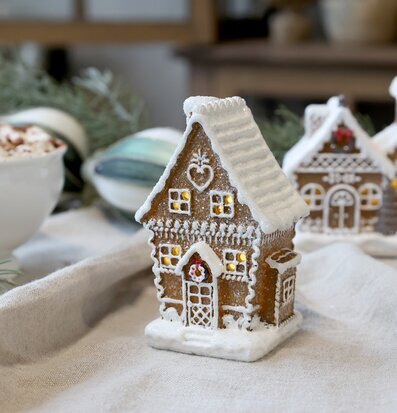 Bild av pepparkakshus med LED-belysning i julig miljö