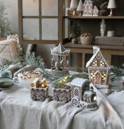 Bild av vintrig inomhusmiljö med pepparkakshus och belysning