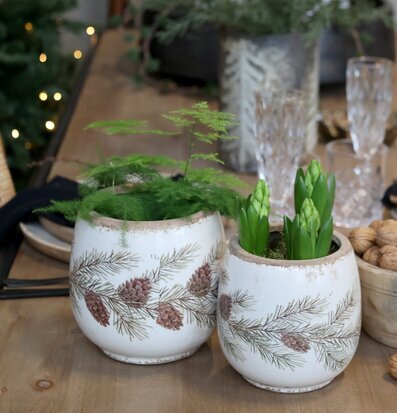 Bild på julig dukning med naturmaterial och rustika krukor