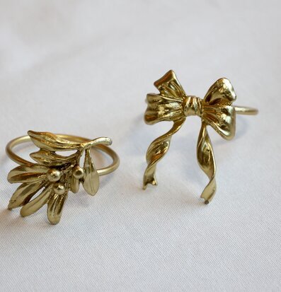 Bild på servettringar i mässing med rosett och växtmotiv