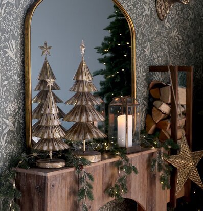 Bild av juldekorerat rum med mässingsgranar och kamin