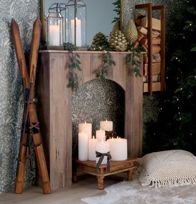 Bild på hemtrevligt vardagsrum med öppen spis och vinterdekor