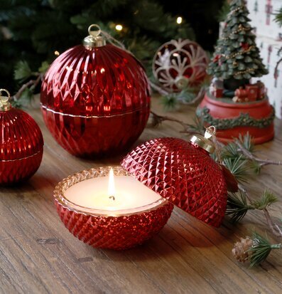 Bild av röd julkula med ljus och klassiska juldekorationer