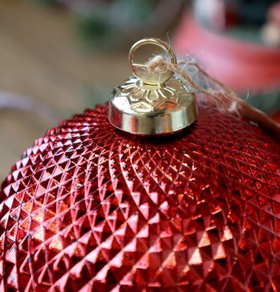 Bild på röd julkula med gyllene fäste och diamantmönster