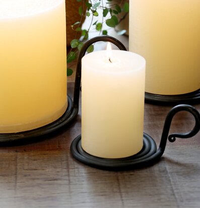 Bild på tända blockljus och kammarljusstake i harmonisk miljö