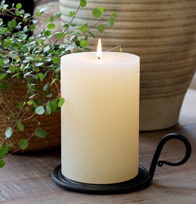 Bild med kammarljusstake, blockljus och växter på träbord