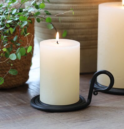 Bild av spiralformad kammarljusstake med blockljus och växt