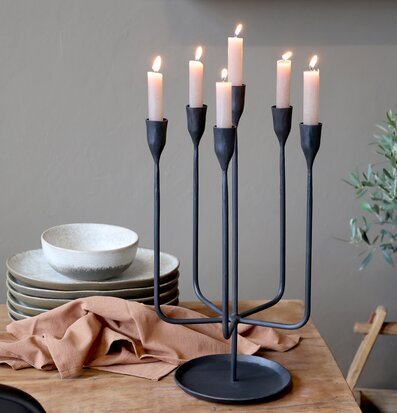 Bild på elegant svart ljusstake och rustikt dukat träbord