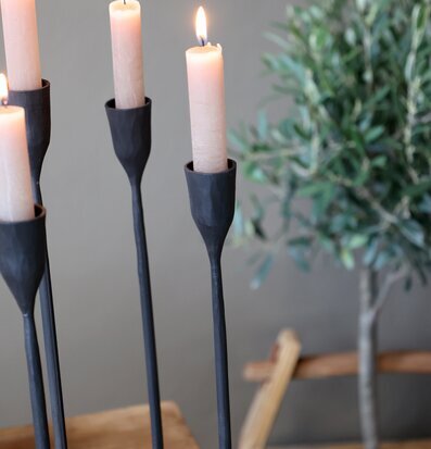 Bild av stämningsfull inredning med svart ljusstake och trä