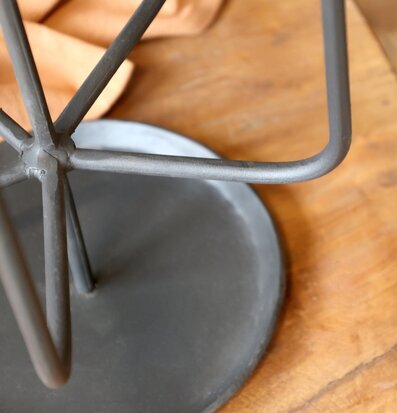 Bild på antiksvart ljusstake i metall med trä och tygdetaljer